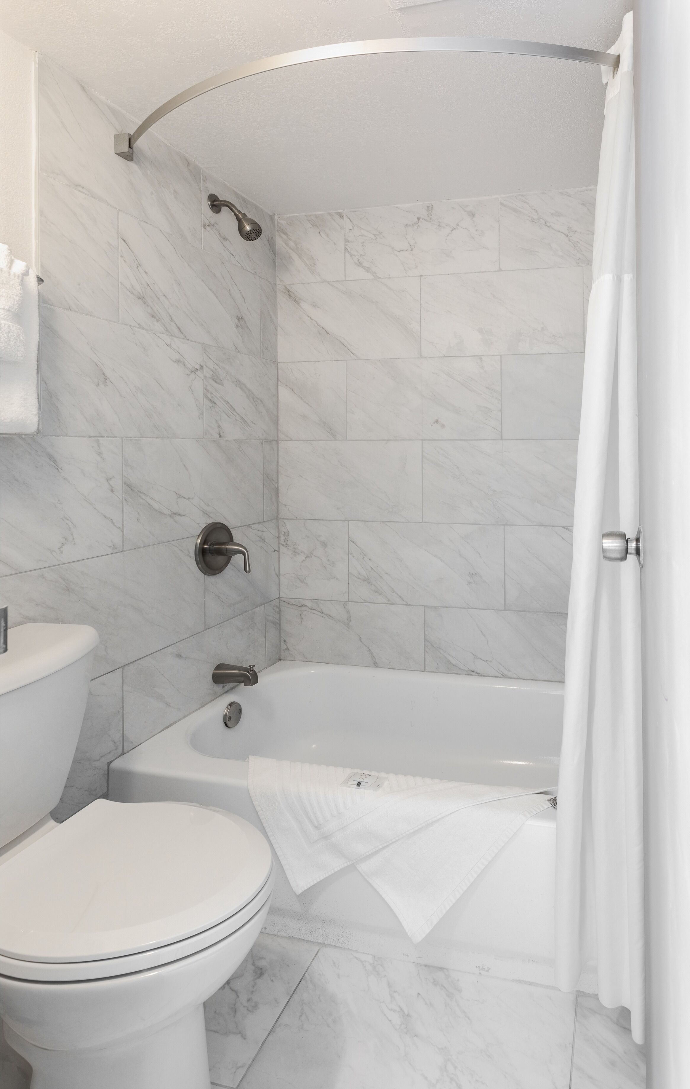 Une salle de bain équipée de toilettes, d’une baignoire et d’un rideau de douche.