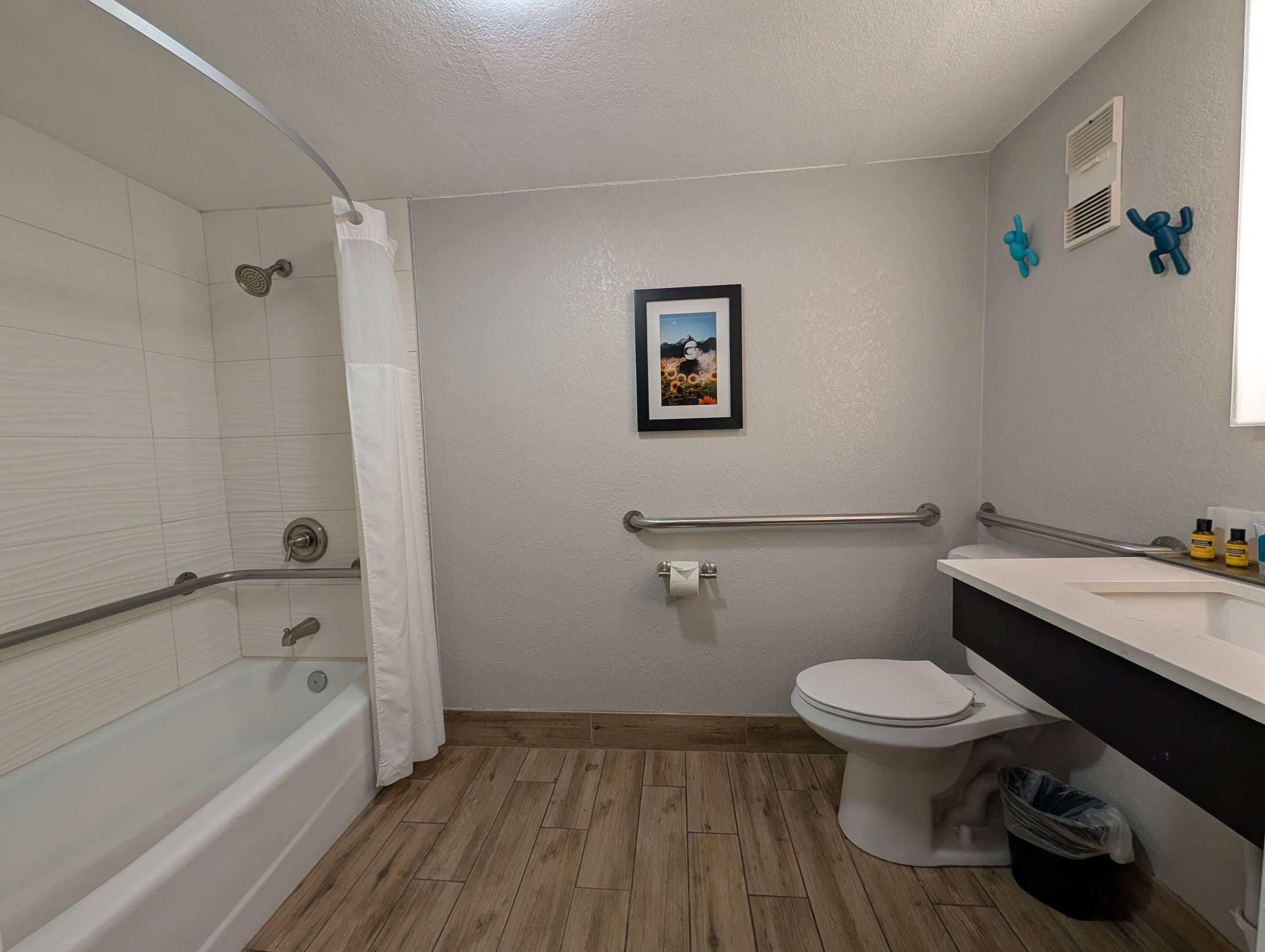 A bathroom with a bathtub, toilet, and shower.