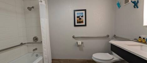 A bathroom with a bathtub, toilet, and shower.