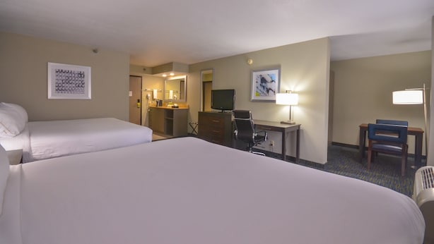 A hotel room with two beds, a desk, a chair, a television, and artwork on the walls. - Holiday Inn Express Fayetteville- Univ of AR Area by IHG (Fayetteville)