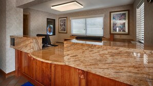 A reception area with a marble counter, wooden paneling, and artwork on the walls.
