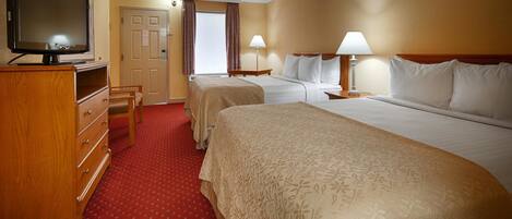 A hotel room with two beds, a TV, a desk, and a chair.