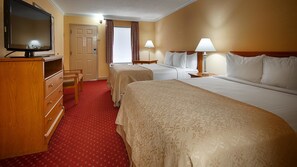 A hotel room with two beds, a TV, a desk, and a chair.