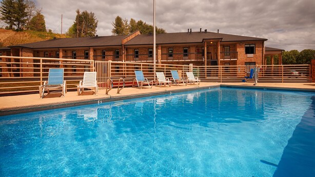 A swimming pool with lounge chairs and a building in the background.
