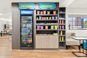 A vending machine labeled 'REFRESH' and 'NOURISH' with snacks and drinks.