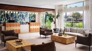 A modern lobby with a reception desk, sofas, and a coffee table.