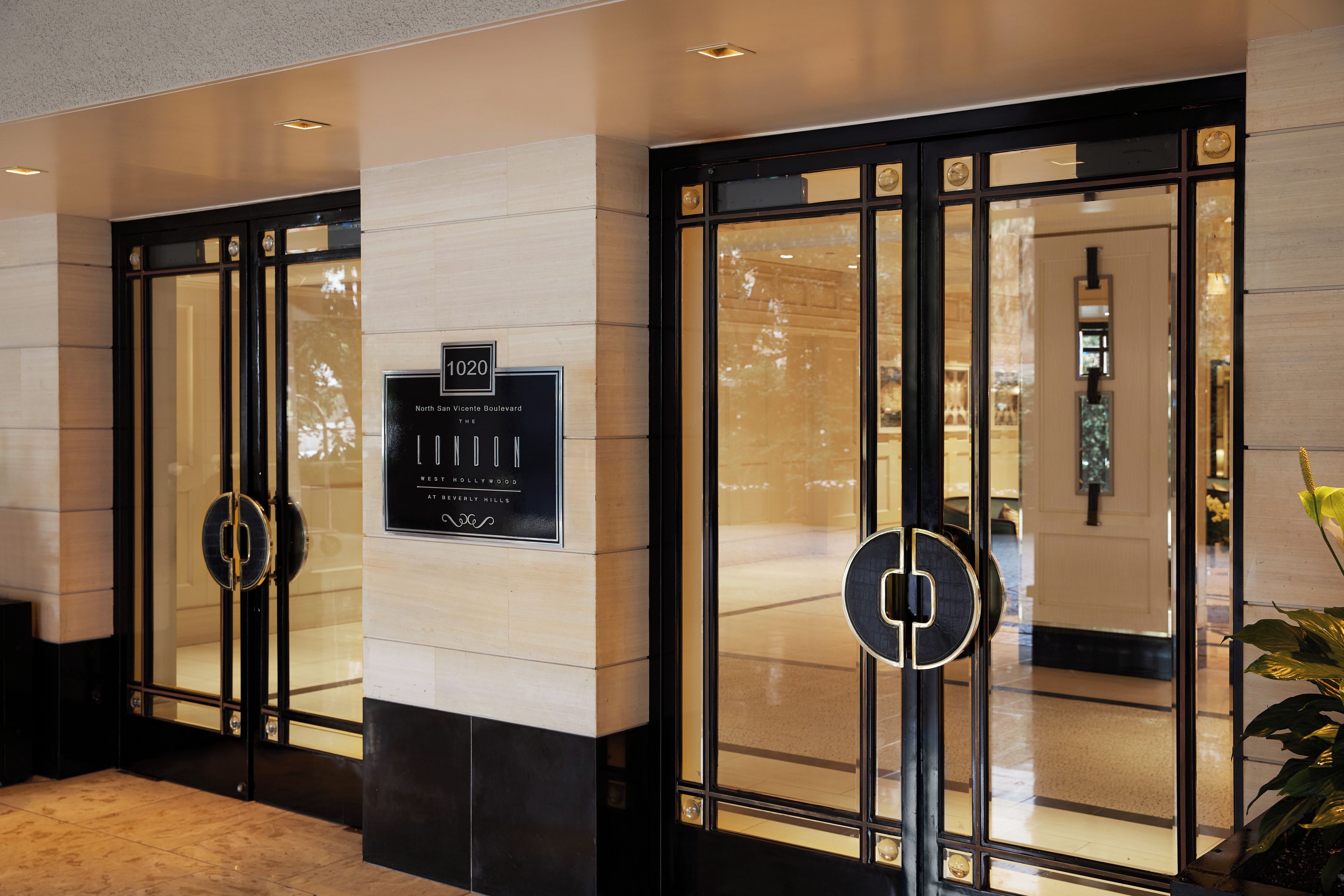 A hotel entrance with a sign indicating the address and name.
