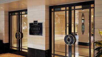 A hotel entrance with a sign indicating the address and name.