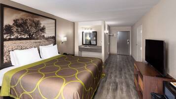 A hotel room with a large bed, a TV, a bathroom with a mirror, and a door leading to another room.