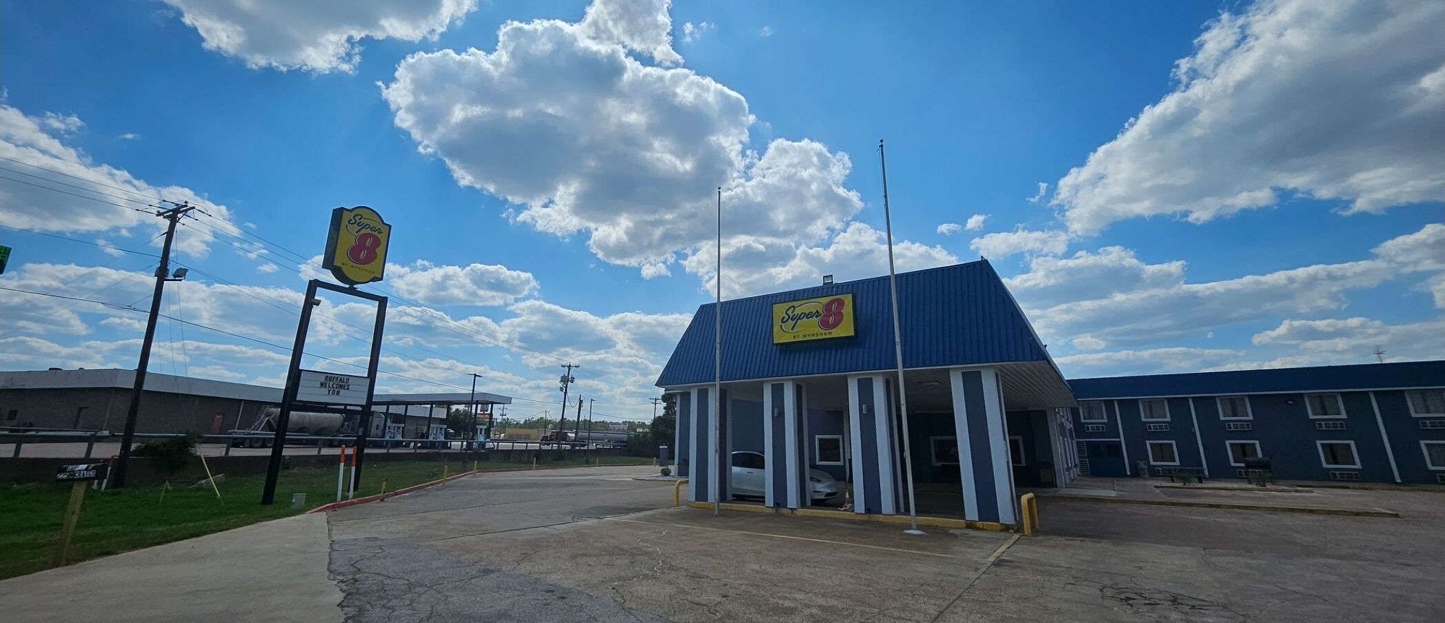 Een Super 8 motel met een blauw dak en een bord.