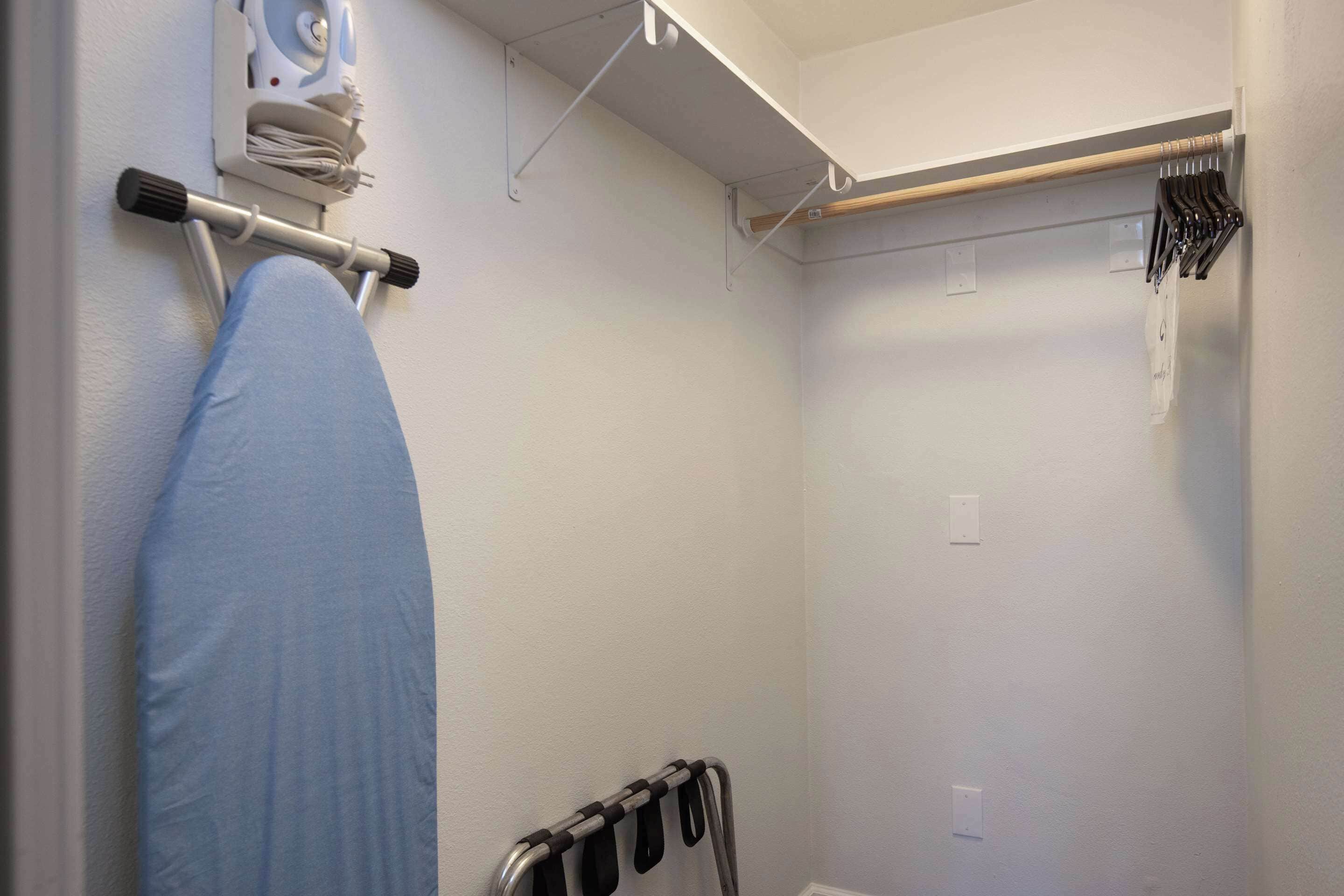 Une chambre comprenant un lit, une table de chevet et une étagère murale avec un distributeur de serviettes et un porte-serviettes.