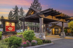 A hotel entrance with a covered walkway, a Best Western PLUS sign, and a stone facade.