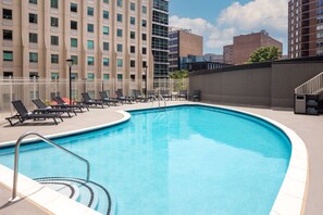 Una piscina al aire libre de temporada, tumbonas