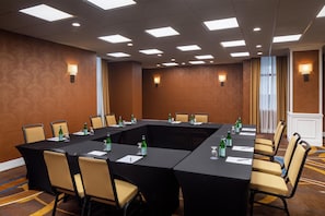 A conference room with a rectangular table, chairs, and wall-mounted lamps. - Doubletree by Hilton Washington DC Silver Spring (Silver Spring)