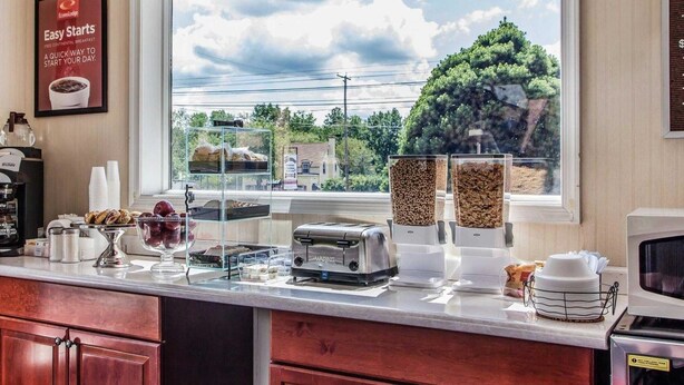 A breakfast bar with cereal, pastries, and a coffee machine. - Econo Lodge Douglassville - Pottstown (Douglassville)