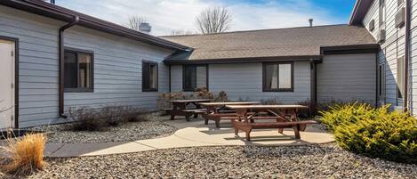 A Red Roof Inn & Suites with a patio area, outdoor seating, and a gravel ground cover.