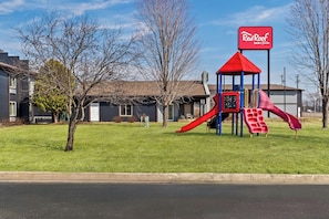 A playground with a red slide and a Red Roof Inn sign. - Red Roof Inn & Suites Tomah (Tomah)