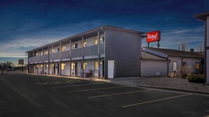 A hotel with a flat facade, multiple balconies, and a parking lot. - Red Roof Inn & Suites Tomah (Tomah)