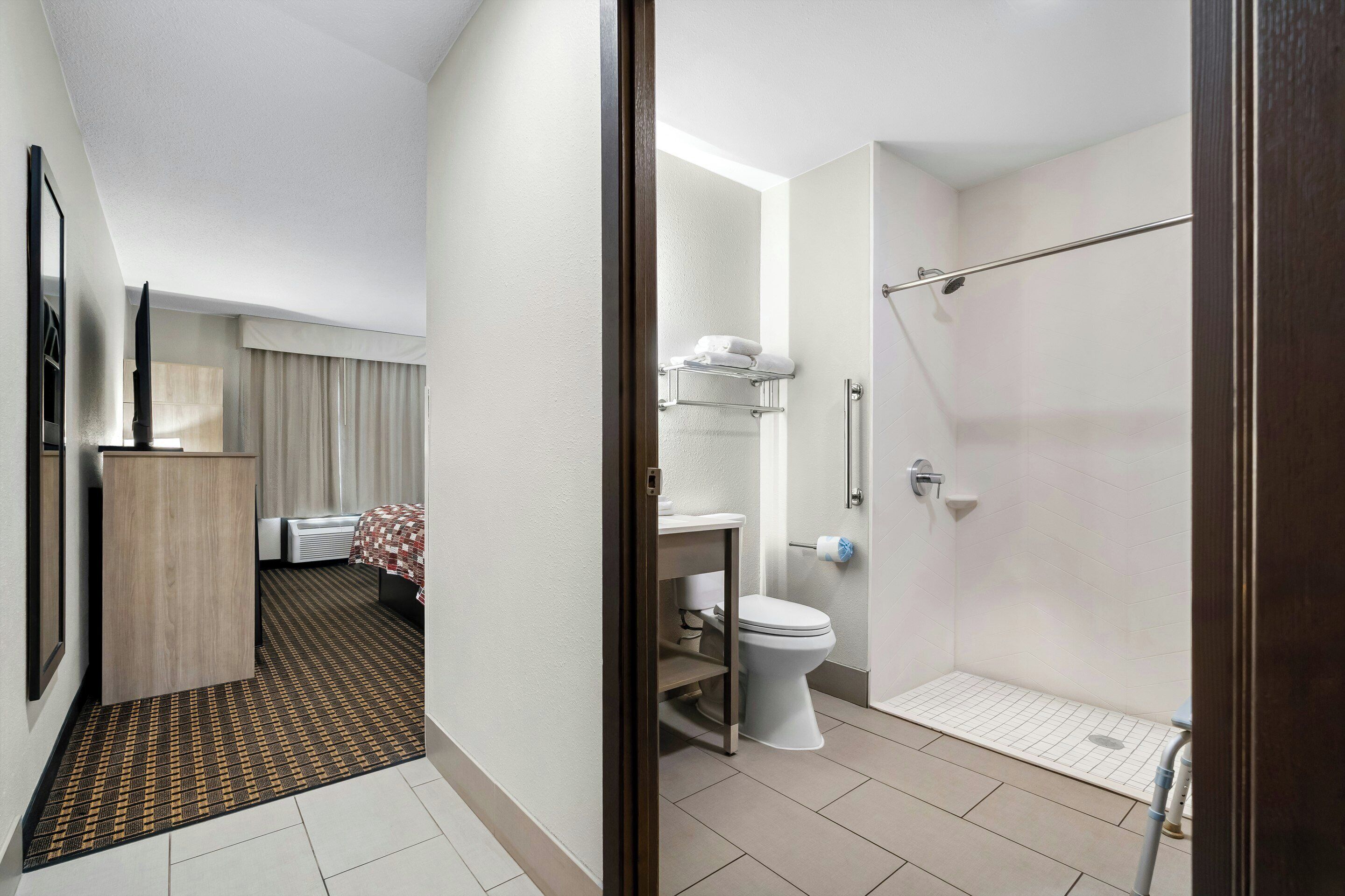 Un baño de hotel con ducha, inodoro y lavabo.