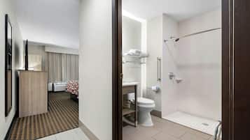 Un baño de hotel con ducha, inodoro y lavabo.