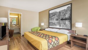 A hotel room with a bed, a desk with a computer, a chair, and a large window. - ASHEVILLE AIRPORT INN (Fletcher)