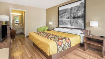 Une chambre d’hôtel avec un lit, un bureau équipé d’un ordinateur, une chaise et une grande fenêtre.