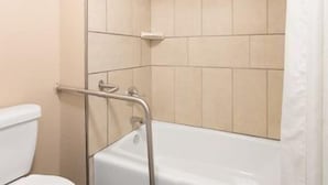 Un baño con bañera, inodoro y zona de ducha.