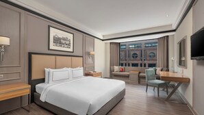 A hotel room with a large bed, a desk, a chair, a sofa, and a TV. - Melia Kuala Lumpur (Kuala Lumpur)