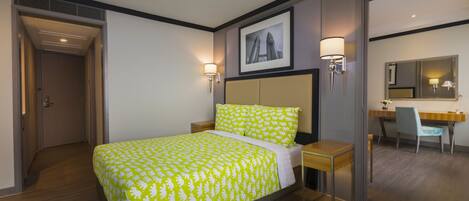Una habitación de hotel con cama, mesitas de noche, un escritorio y una silla.