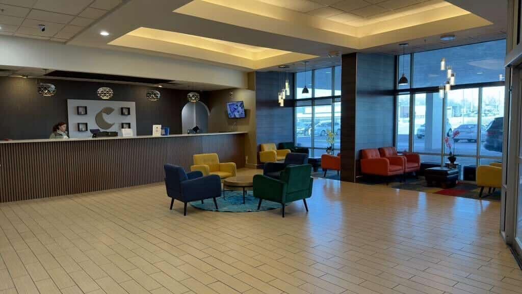 A reception area with a counter, seating, and large windows.