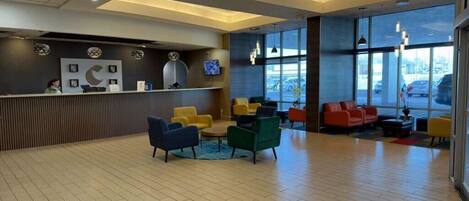 A reception area with a counter, seating, and large windows.