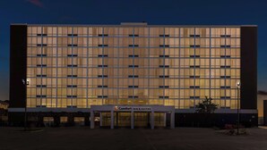 A large hotel with a modern glass facade, a central entrance, and a sign for Comfort Inn & Suites. - Comfort Inn & Suites Omaha Central (Omaha)