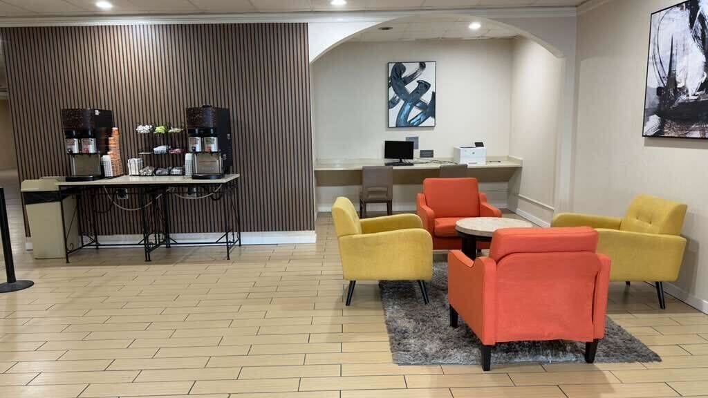 Un espacio moderno de sala de estar con bar, asientos y una estación de computadoras.