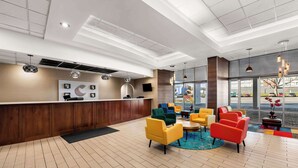 A hotel lobby with a reception desk, seating area with colorful chairs, and large windows offering a view of the parking lot. - Comfort Inn & Suites Omaha Central (Omaha)