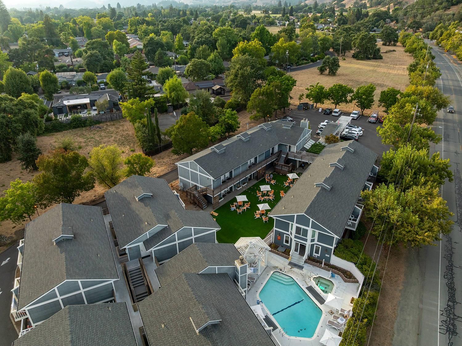 A residential area with a large building featuring a swimming pool and outdoor seating.