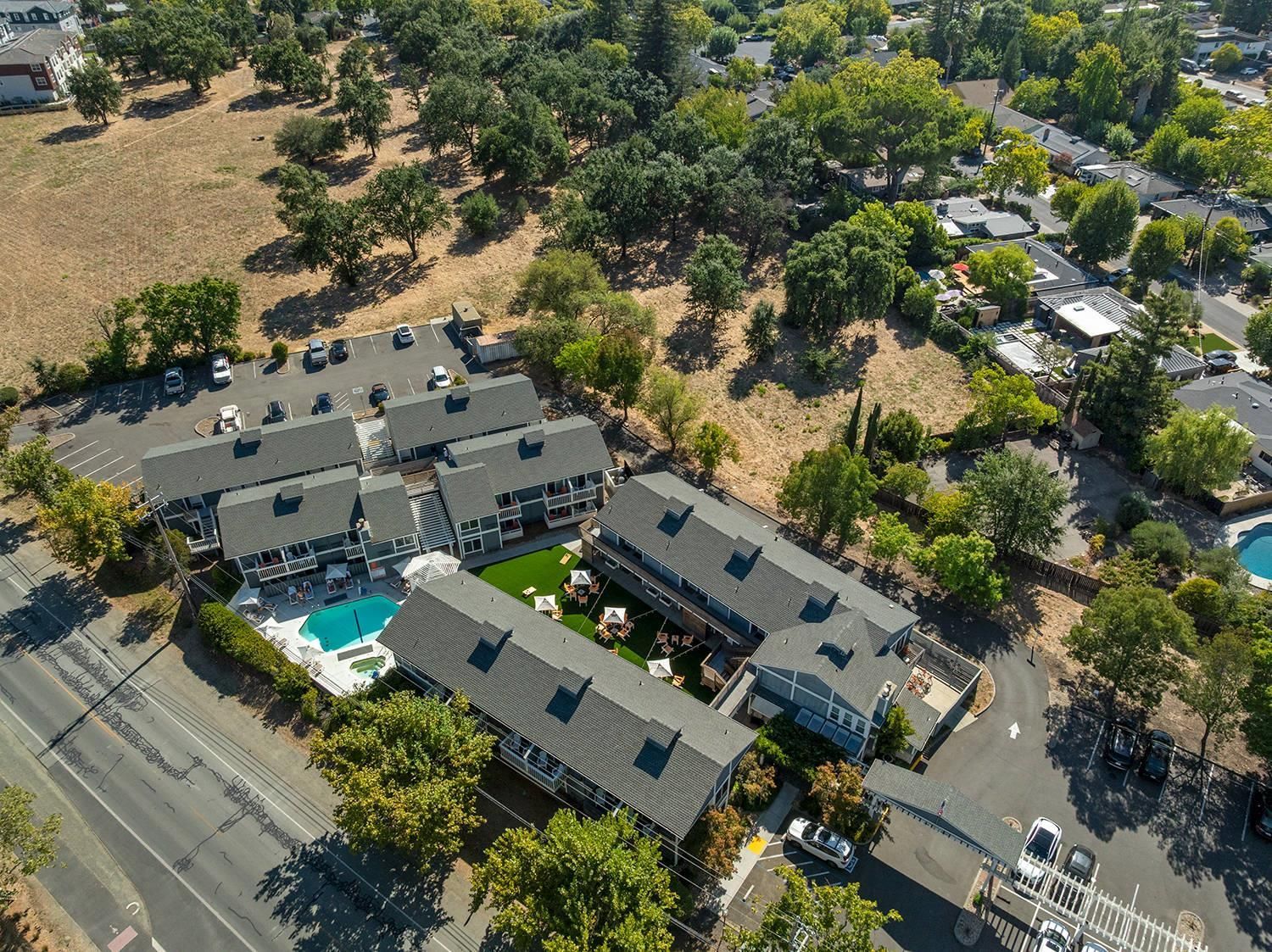Vista aérea de un área residencial con varias casas, una piscina y un estacionamiento.
