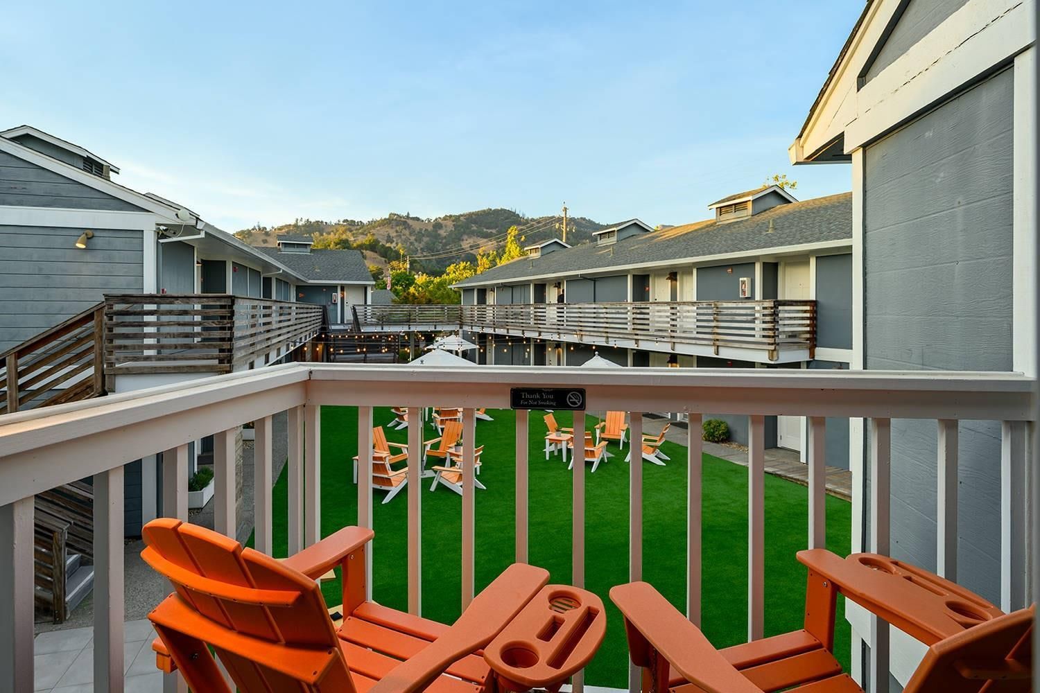 A hotel with a balcony area featuring outdoor seating and a view of the surrounding landscape.