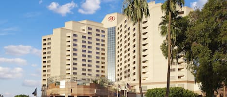 A hotel with multiple floors, a glass facade, and a prominent Hilton logo.
