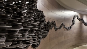 A modern interior with a unique wall design featuring a series of metallic, wave-like structures. - Hilton Long Beach Hotel (Long Beach)
