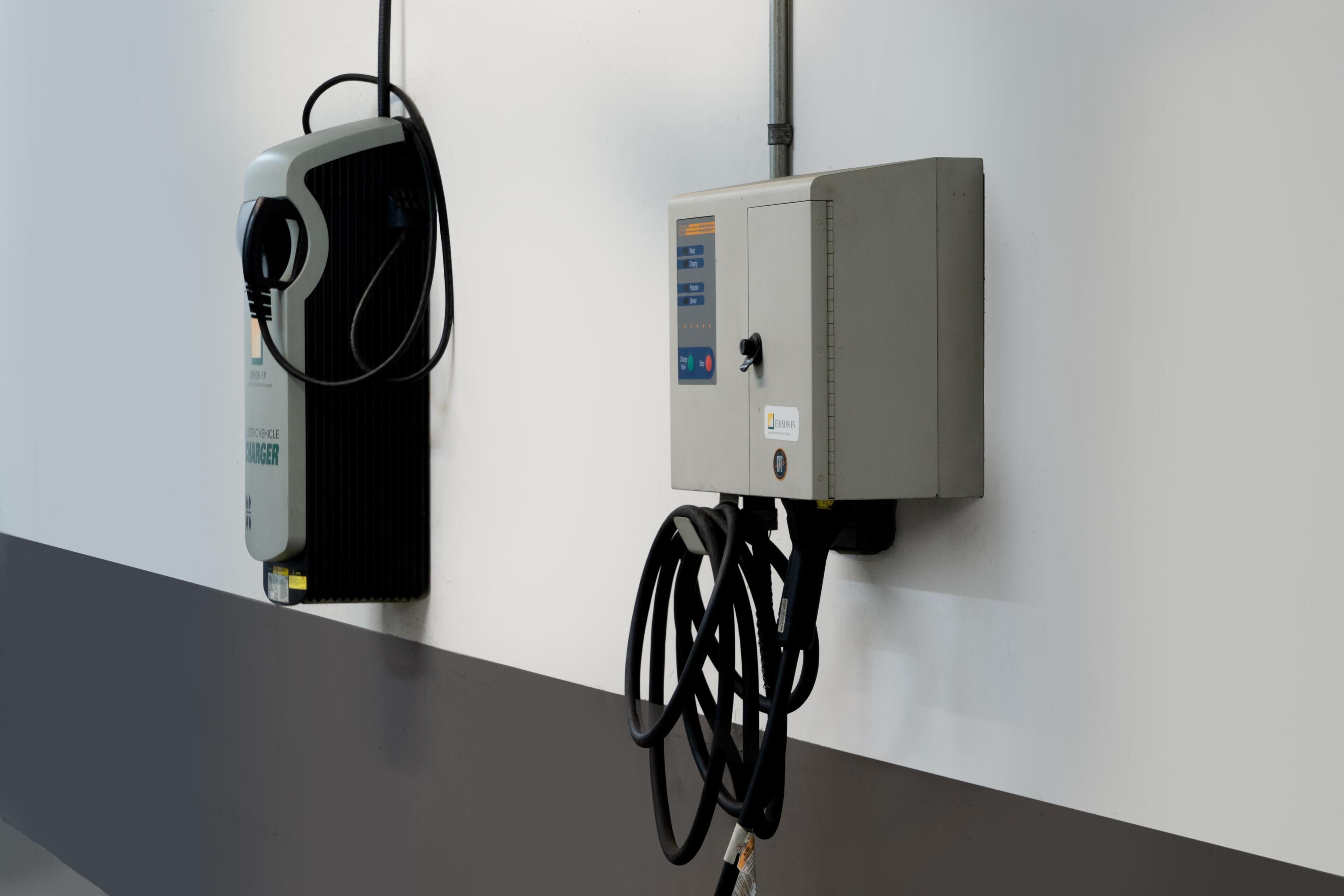A control panel and a device mounted on a wall with a cable connected to it.