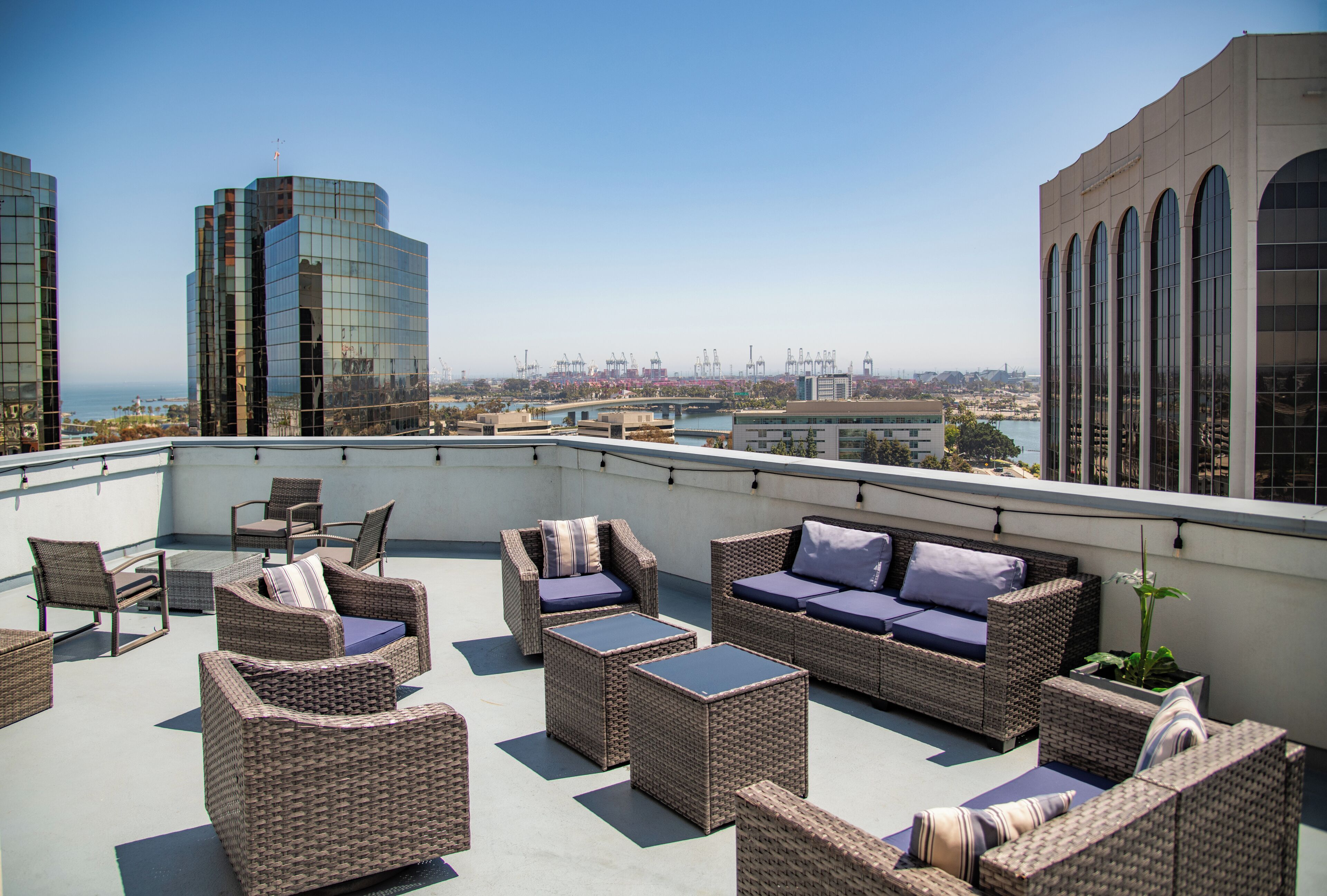 A rooftop terrace with wicker furniture and a view of the cityscape.