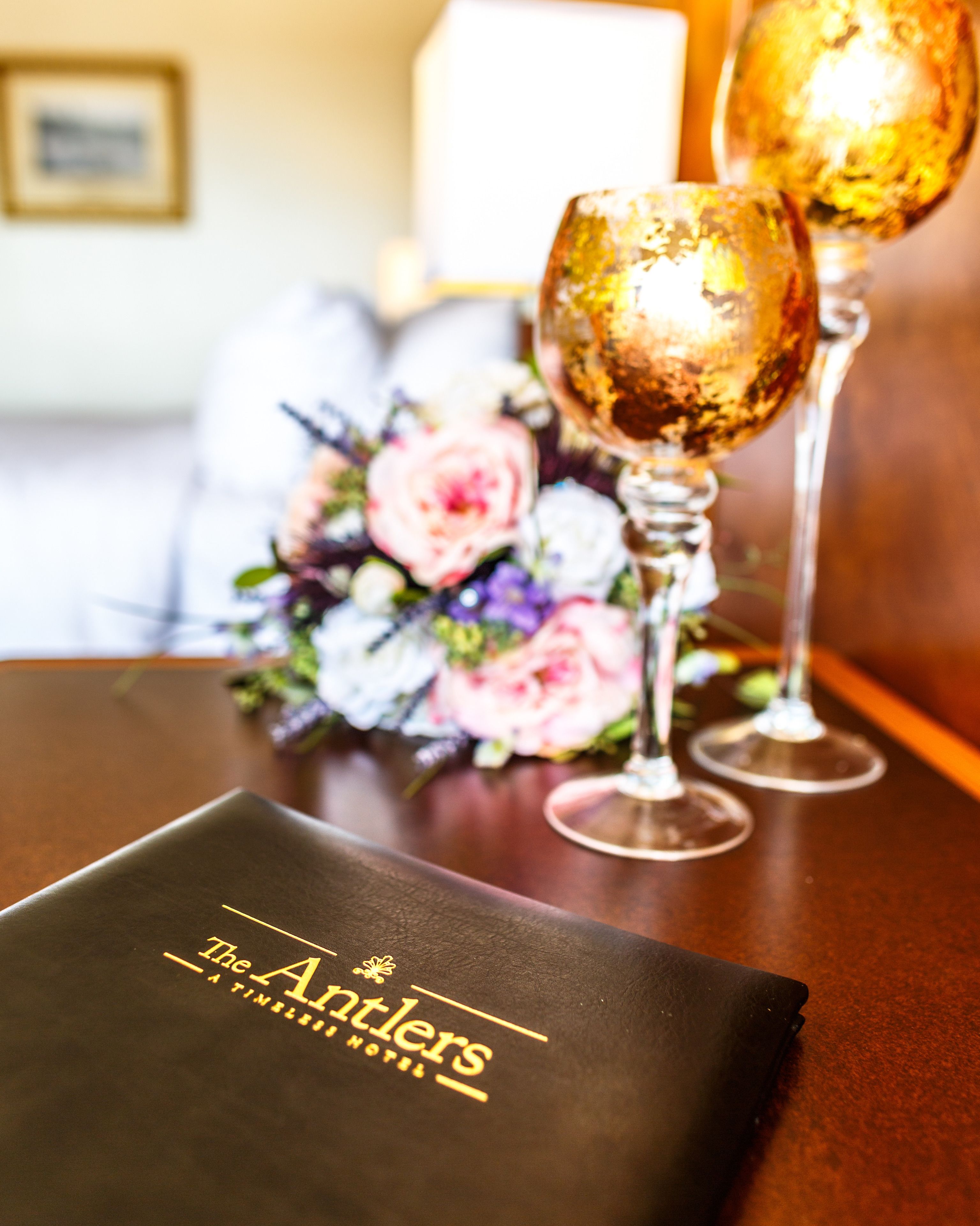 A table with a menu and two glasses of champagne.