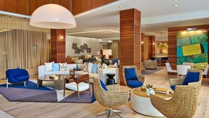 A spacious lobby with a modern design, featuring a mix of seating options including sofas and chairs, a coffee table, and a decorative wall with abstract art. - The Westin San Diego Gaslamp Quarter (San Diego)