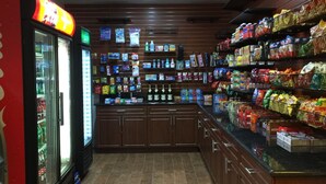 A convenience store interior with refrigerated sections, shelves stocked with snacks, and a variety of packaged goods. - Ramada by Wyndham Sacramento (Sacramento)