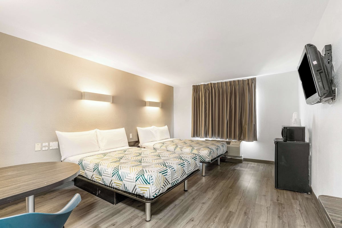 Minibar, escritorio, cortinas blackout y tabla de planchar con plancha