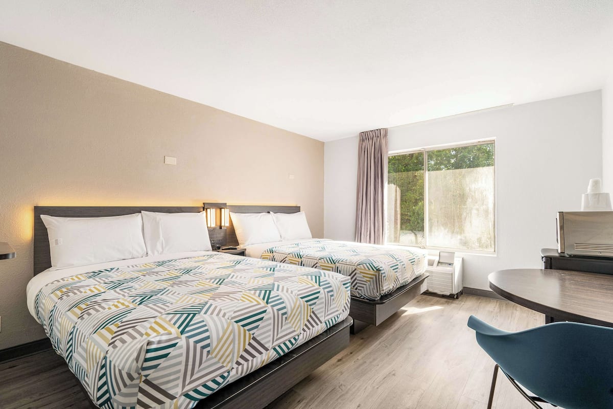 Minibar, escritorio, cortinas blackout y tabla de planchar con plancha