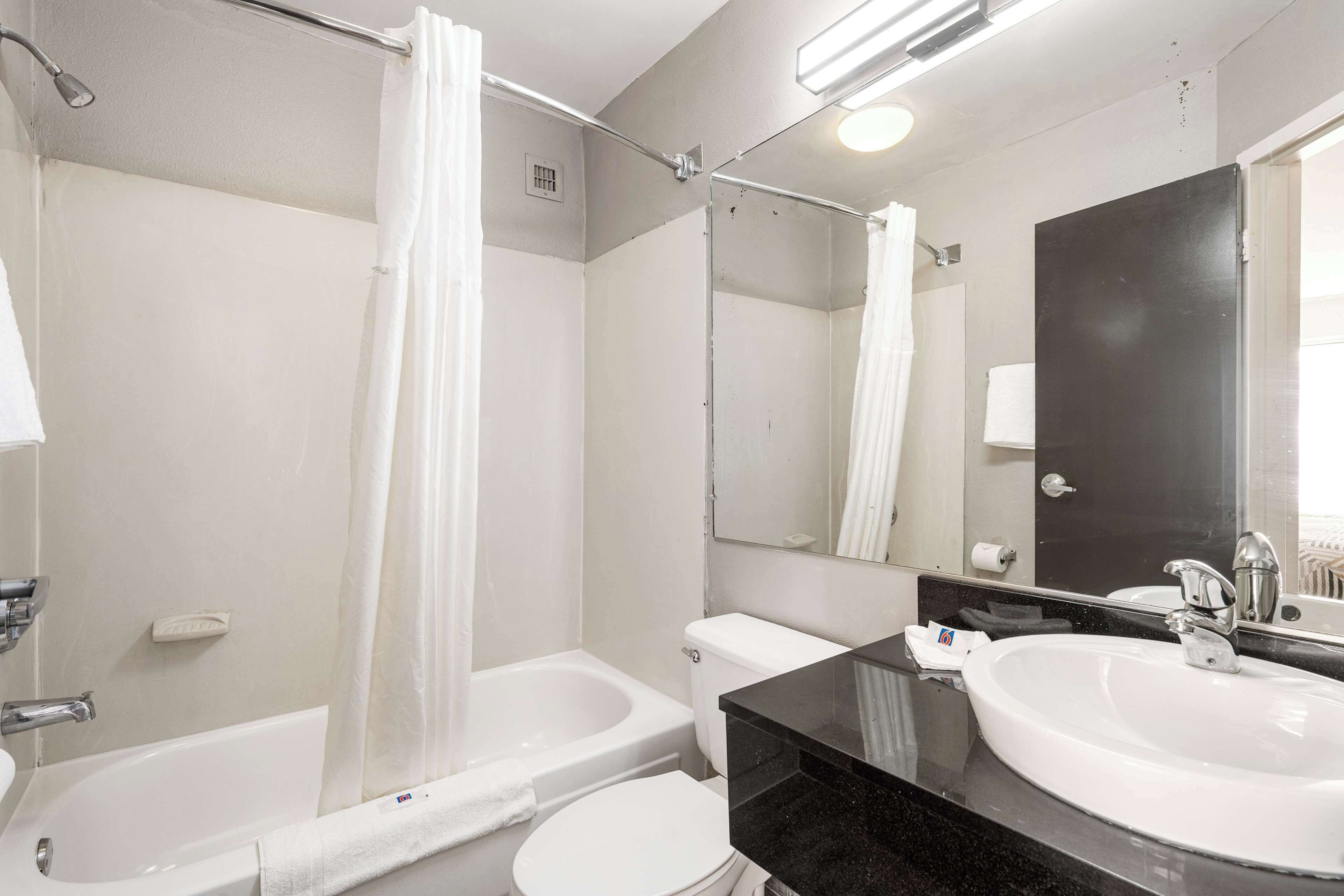 Une salle de bain moderne équipée d’une baignoire, de toilettes et d’un lavabo.