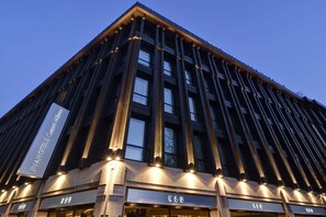 Un edificio moderno con fachada oscura y señalización iluminada.