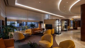 Eine großzügige Lobby mit einer gebogenen Sitzgruppe, großen Fenstern und einem modernen Innenarchitekturstil.