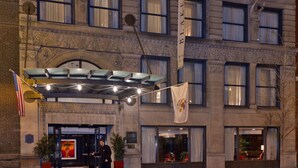 A hotel entrance with a marquee, American flag, and a person standing in front. - Hilton Vacation Club Hotel Blake Chicago (Chicago)